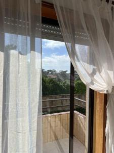 a window with white curtains and a view at Lovely 2 bedroom apartment 100m from the beach in Vila do Conde