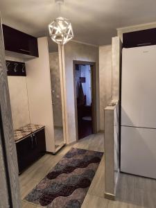 a kitchen with a refrigerator and a chandelier at Andi Apartment Suceava in Ipoteşti +2 photos