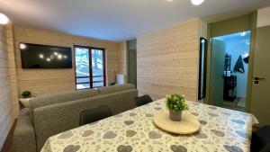 a living room with a table and a couch at Lys Apartment in Gressoney-la-Trinité