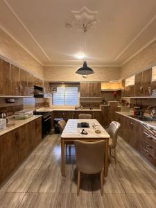 een keuken met houten kasten en een tafel en stoelen bij شقق مفروشة 22 in Al Madinah
