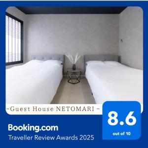 大阪市にある4F Guest House NETOMARI 西九条駅から徒歩2分の部屋には白いシーツが敷かれたベッドが2つ