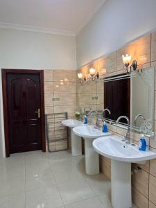 een badkamer met twee wastafels en een grote spiegel bij شقق مفروشة 22 in Al Madinah