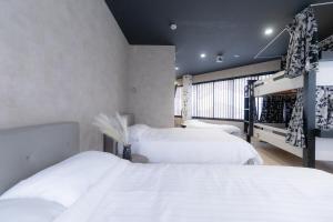 大阪市にある4F Guest House NETOMARI 西九条駅から徒歩2分のベッドが3つと窓のある寝室 +37枚の写真