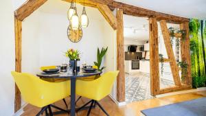 a dining room with a table and yellow chairs at Luxx Home RV, City Marienplatz in Ravensburg