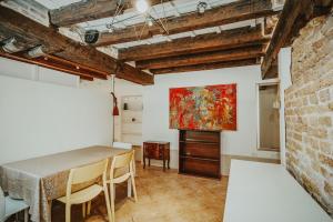 una sala da pranzo con tavolo e un dipinto sul muro di Autentico rifugio veneziano Bilocale nel cuore di Cannaregio a Venezia