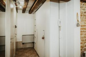 un corridoio con porte bianche e un muro di mattoni di Autentico rifugio veneziano Bilocale nel cuore di Cannaregio a Venezia