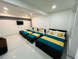 a room with two beds and a tv in it at 4 Axes Deluxe Family Studio Ella in Badulla