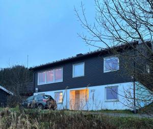 una casa nera con una macchina parcheggiata di fronte di Hus med havutsikt i vakre Vesterålen - naboen til Lofoten a Sortland Altre 20 foto