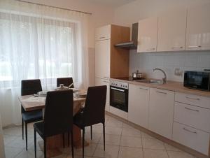 a kitchen with a table and chairs and a kitchen with white cabinets at Maria&Beppi in Umag