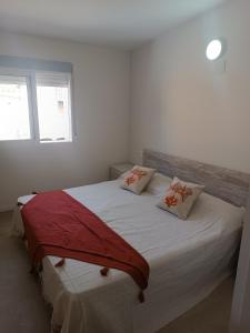 Un dormitorio con una gran cama blanca con dos almohadas. en CASA TURQUESA, en Torrealvilla
