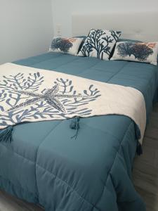 Dos camas con sábanas y almohadas azules y blancas. en CASA TURQUESA, en Torrealvilla