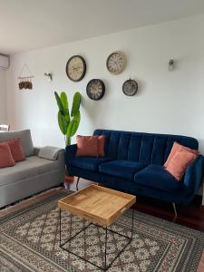 马达莱纳SanMar的客厅配有蓝色的沙发和墙上的时钟