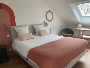 1 dormitorio con 1 cama grande y 2 almohadas rosas en La Passerelle, en Morlaix