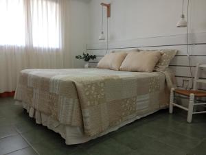 um quarto com uma cama com um cobertor em cima em Socaire, tu refugio en Chascomús em Chascomús