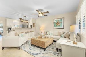 una sala de estar con un sofá y una mesa en Naples Oasis SwimSpa Tiki Bar Arcade and Fire Pit By Vacation Your Way, en Naples