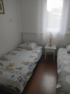 1 Schlafzimmer mit 2 Betten, einer Lampe und einem Fenster in der Unterkunft Chez Marielle in Parentis-en-Born + 16 Fotos