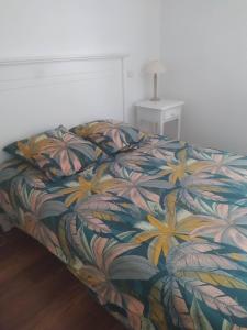 1 Schlafzimmer mit einem Bett mit einer bunten Blumenbettdecke in der Unterkunft Chez Marielle in Parentis-en-Born