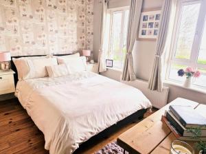 a bedroom with a bed and a table and windows at Teach Na Sióga in Lehardan