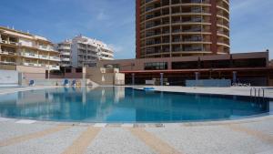 an empty swimming pool in front of some buildings at High In The Sky in Portimão