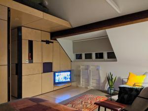 a living room with a couch and a tv in a room at Browhill Loft - contemporary, handcrafted studio in Danehill