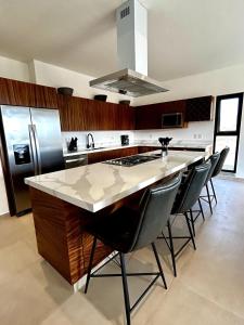 a kitchen with a large island with black chairs at Los Cerritos Oceanview at The Point,8 in San Carlos