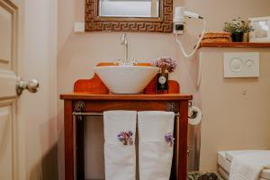 a bathroom with a sink and a counter with towels at Bozcaada Biz Otel in Bozcaada