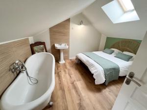 a bathroom with a bed and a bath tub next to a bed at Gîte de la Sablonnière in Haut-Orbé