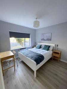 a bedroom with a large bed and a window at Luxury By The Coast- sleeps 4 in Galway