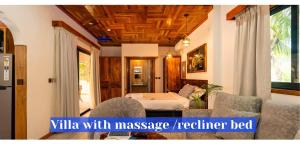 a bedroom with a bed and chairs and avisor at Alibel Beach Villa in Anse a La Mouche