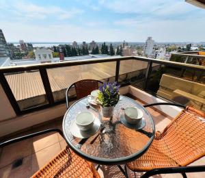a table and chairs on a balcony with a view at Excelente departamento, a metros del Shopping Paso del Paraná, vista al río Paraná - silencio - ideal para descansar - barrio residencial - Cámaras de seguridad 24hs - unidad Monitoreada in Paraná