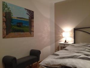 een slaapkamer met een bed en een schilderij aan de muur bij Fewo Vulkaneifel in Tettscheid