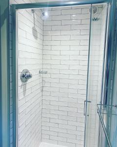 a shower with a glass door in a bathroom at Little Pink Cabin in Church End +21 photos