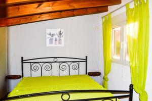 ein Schlafzimmer mit einem Bett mit gelben Laken und einem Fenster in der Unterkunft Naturgelegenes Resort in Alboy + 6 Fotos