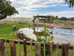 a pond in a yard with a wooden fence at Mount Gerizim Farm in Louisvale