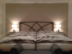 a bedroom with a bed with two lamps on both sides at Fewo Vulkaneifel in Tettscheid