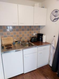 una cucina con mobili bianchi e un lavandino di Zentrale Ferienwohnung in Bergen auf Rügen a Bergen auf Rügen