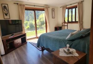 a bedroom with a bed and a flat screen tv at Casona octava región in Concepción