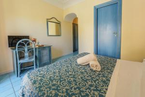 a bedroom with a bed with a blue door and a chair at Hotel Terme Zi Carmela in Forio d'Ischia