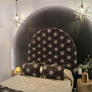a bed with a black and white headboard with pillows at Beautiful penthouse with terrace next to the Cathedral in Cádiz
