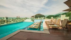 a swimming pool with tables and chairs on a building at Américas Copacabana Hotel in Rio de Janeiro