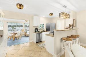 Una cocina y una sala de estar con mostrador y sillas. en Naples Oasis SwimSpa Tiki Bar Arcade and Fire Pit By Vacation Your Way, en Naples 21 fotos más