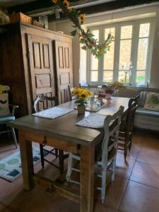 a dining room with a wooden table and chairs at 5Arsouze in Châtelus-le-Marcheix