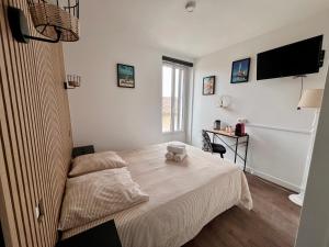 a bedroom with a bed and a television on the wall at logis Paul Massy in Meschers-sur-Gironde