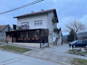 a house with a car parked in front of it at Apartman Marinero in Kutjevo