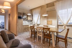 a kitchen and dining room with a wooden table and chairs at L'Erika in Città in Livorno