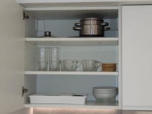 un armario lleno de tazones, platos y vasos en Studio lumineux Bruxelles, en Bruselas 2 fotos más