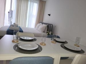 mesa de comedor con platos y vasos y cama en Studio lumineux Bruxelles, en Bruselas