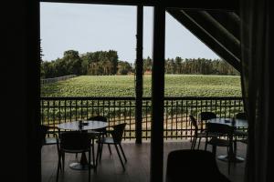 a room with tables and chairs and a view of a field at Apartamenty Winnica Milsko in Milsko