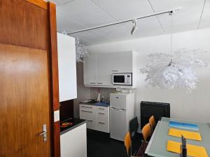 a small kitchen with a table and a microwave at Appartement à 100m des pistes de ski et des commodités in Anzère