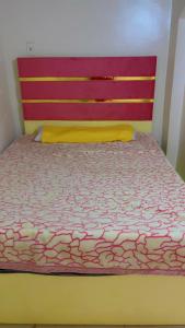 a bedroom with a bed with a red head board at tmem home in Jazīrat Aswān